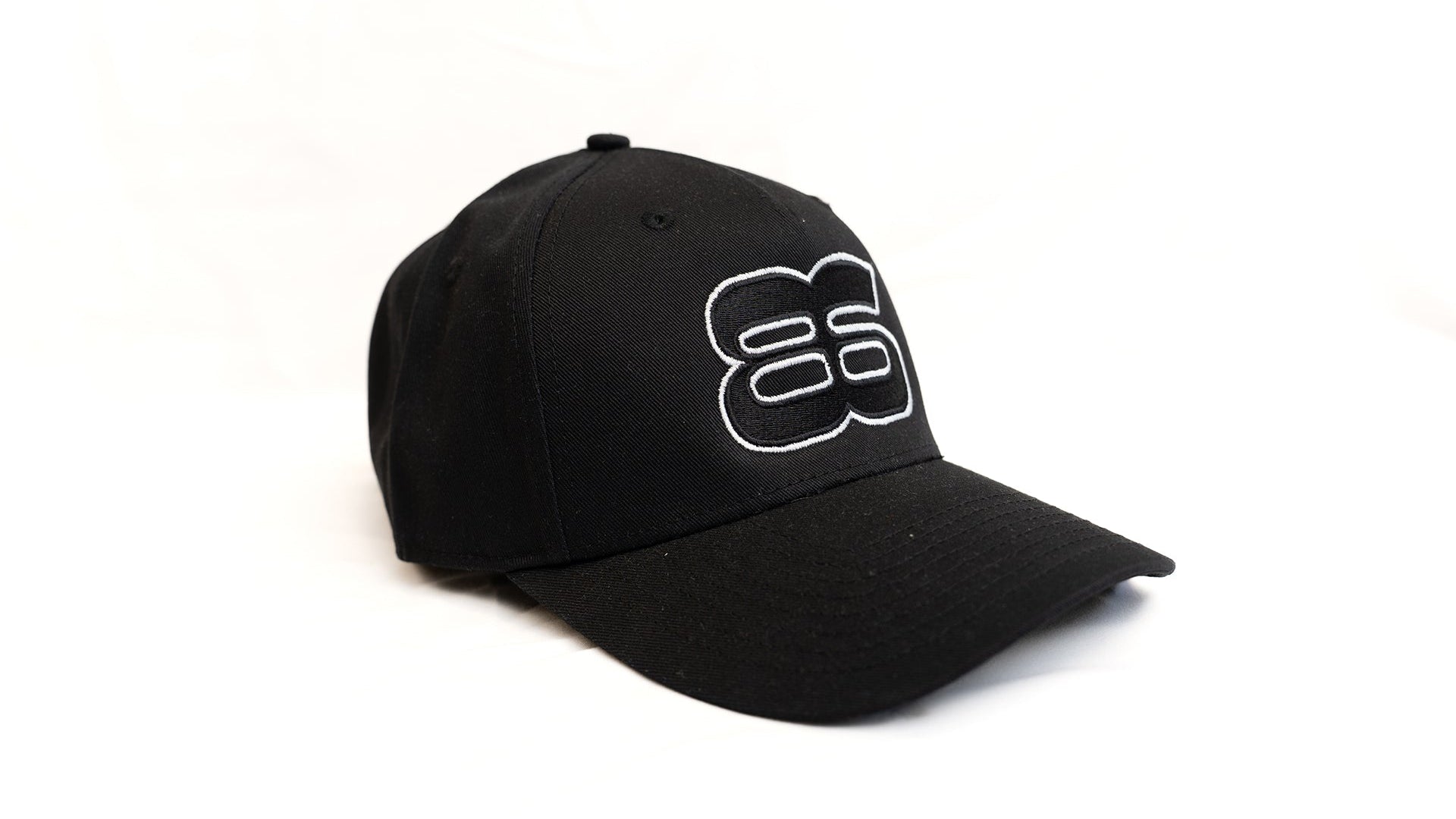 Casquette noire brodée Backstage portée en look streetwear