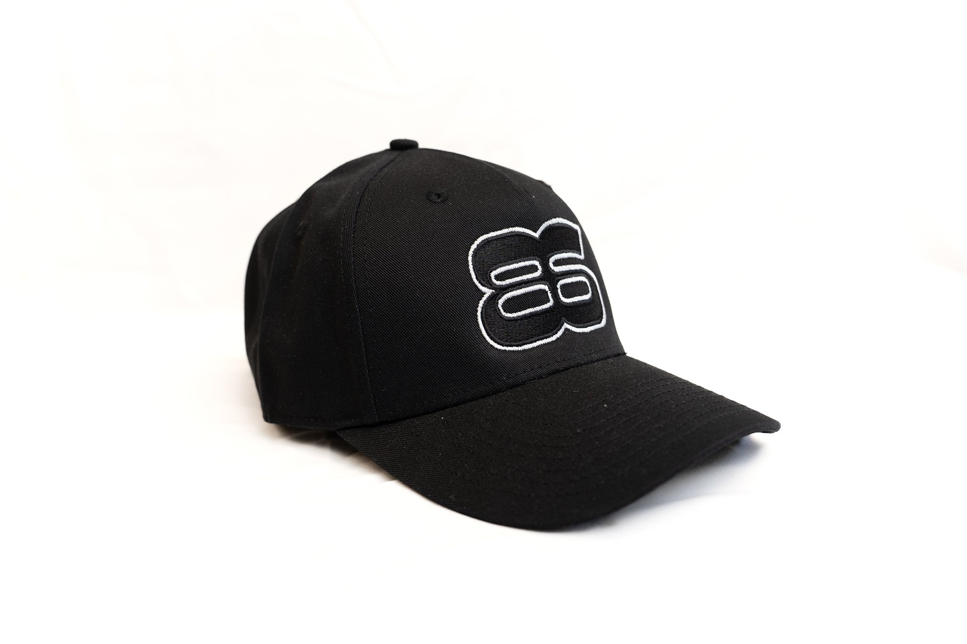 Casquette noire brodée Backstage portée en look streetwear