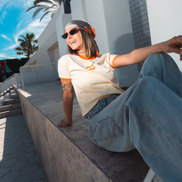 Femme en maillot streetwear Backstage et bandana, assise au soleil