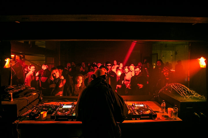 Dancefloor sous lumière verte entre des colonnes, la nuit en club telle que Backstage la raconte