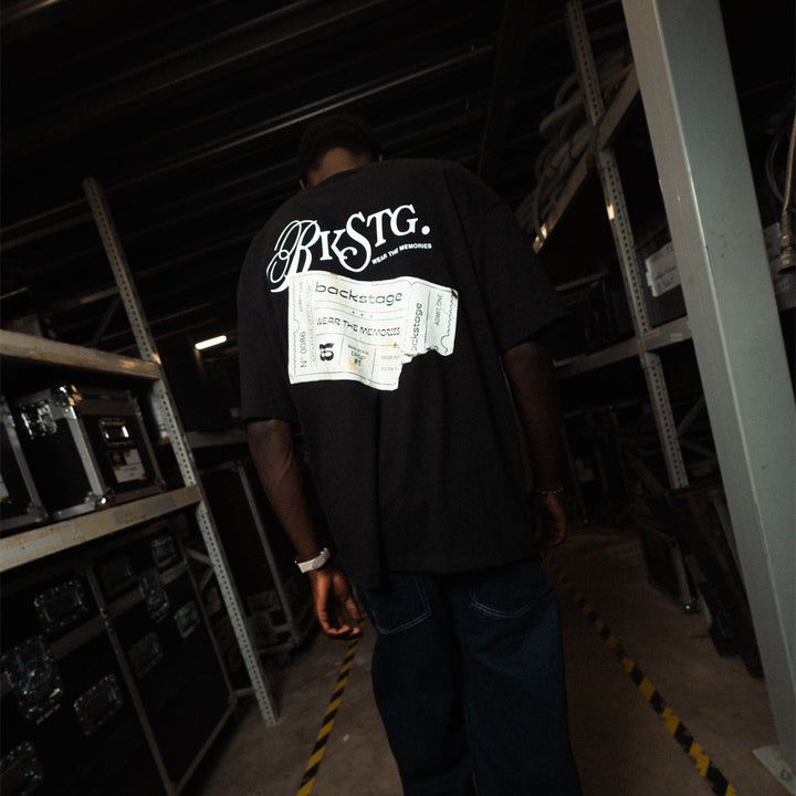 T-shirt oversize noir Backstage imprimé ticket, porté dans les coulisses d'un club