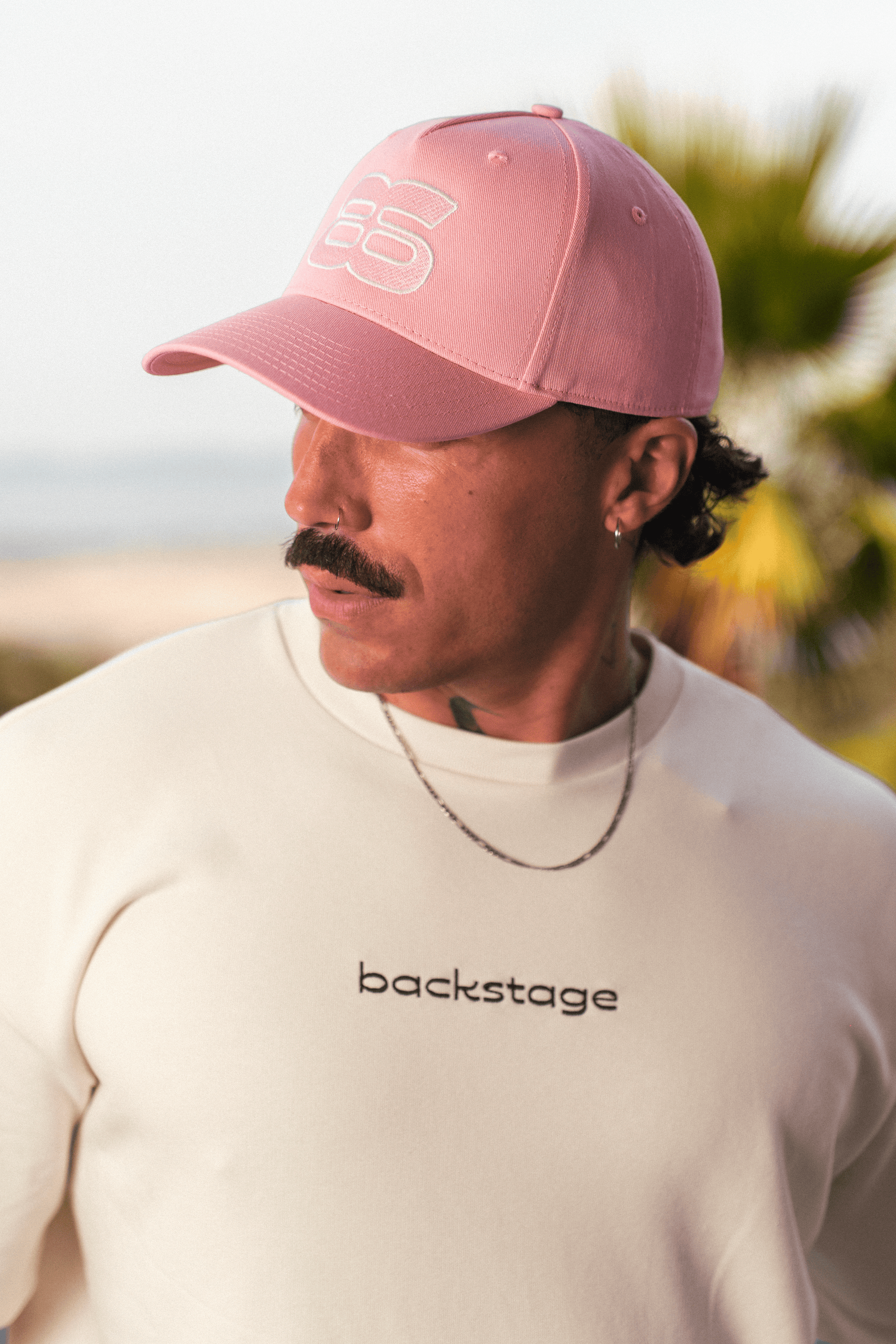 Casquette rose brodée Backstage sur fond neutre